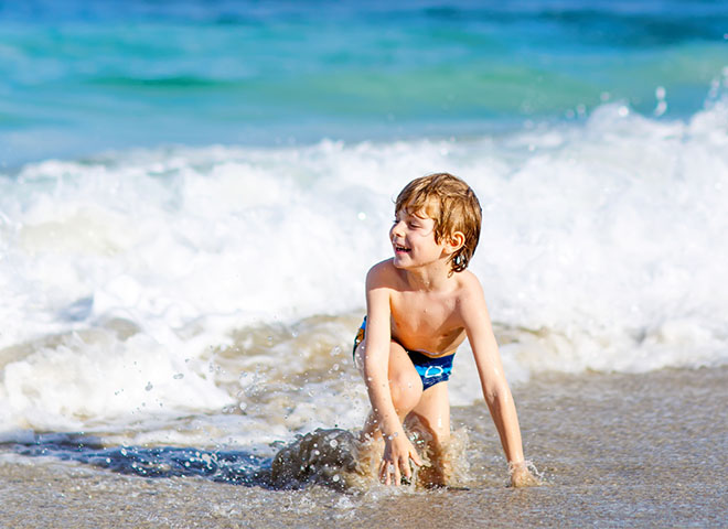 Young boy playing ocean-side