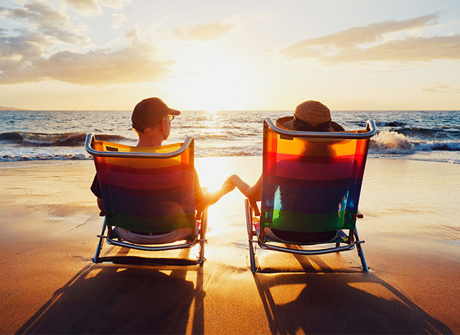 Couple sitting on the beach at sunset