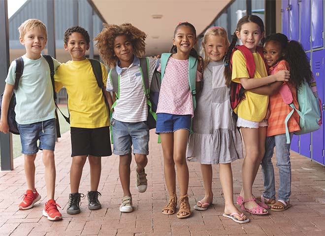 Happy school kids standing in corridor