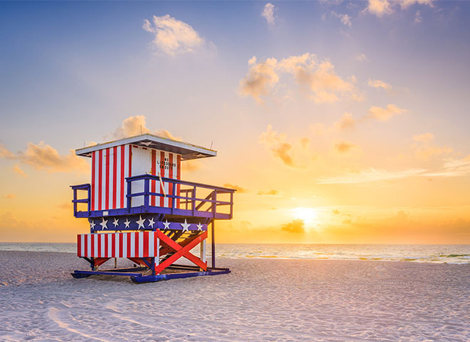 Patriotic lifeguard stand on a beach at sunset