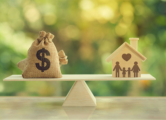 Wood scale with money bag and house