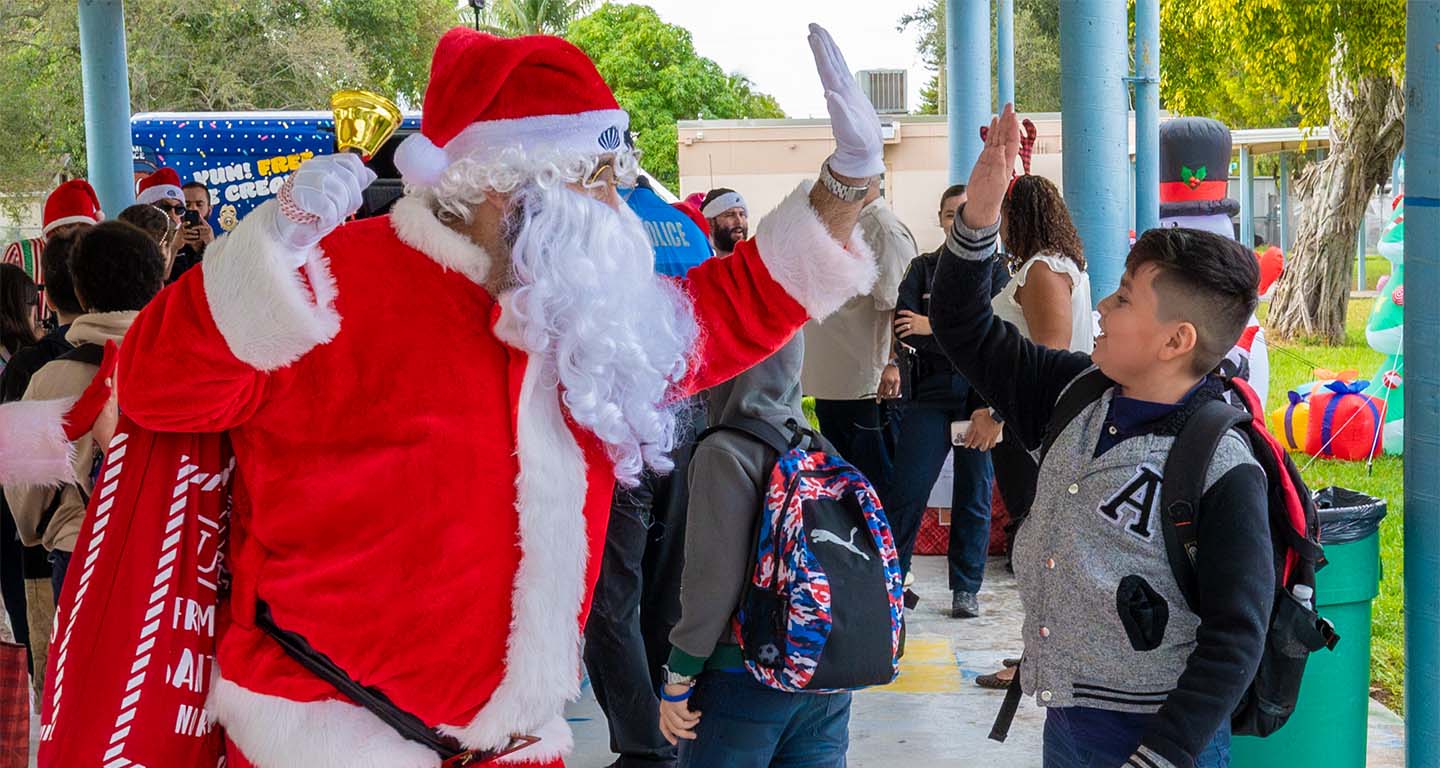 Santa high-fiving a teenager