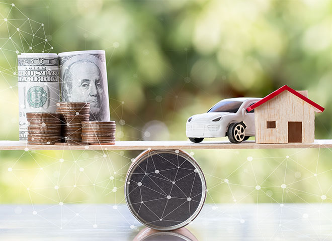 Model home and car with stack of coins on a scale