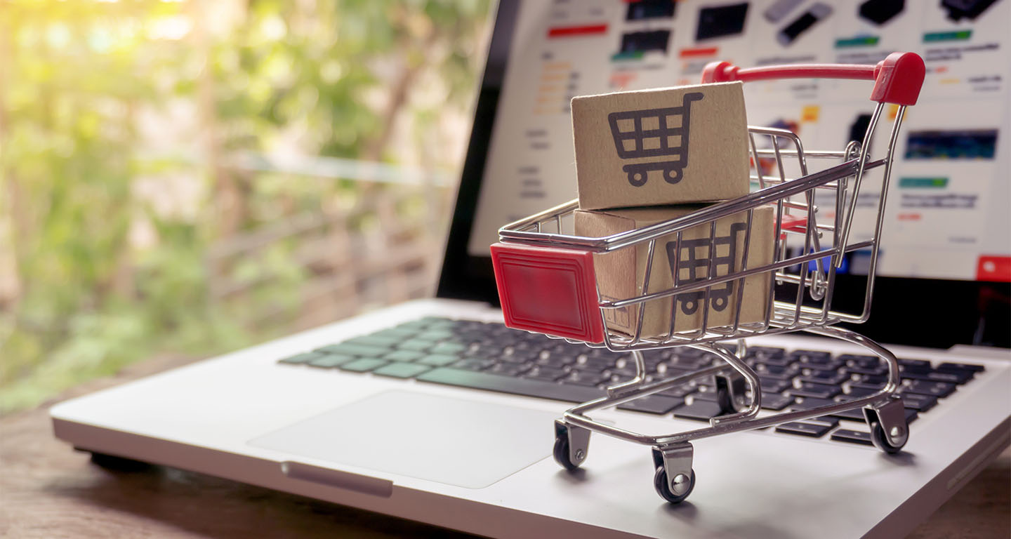 Cartons in a shopping cart on a laptop keyboard