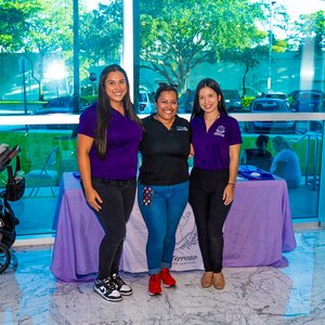Smiling group in front of purple table inside