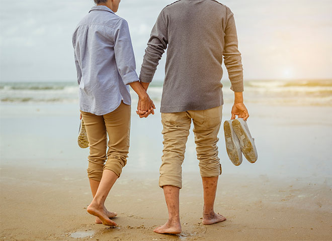 Couple walking on the beach holding hands