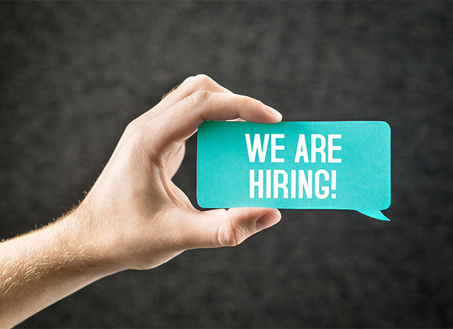 Hand holding 'We are hiring' card